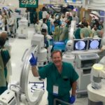 J. Patrick Johnson smiling at camera in crowd of doctors.